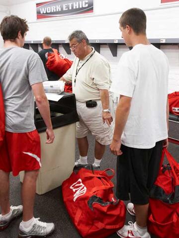 Student workers confer with Paul Pucciarelli to make sure the correct bag is put in the right locker.