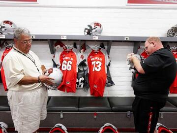 Equipment manager Paul Pucciarelli and volunteer Jeremy Gouker ensure that the helmets are ready to go.