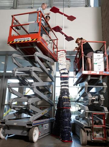 Artist Troy Gillett installs "Common Threads" in the entrance of Lied Library.