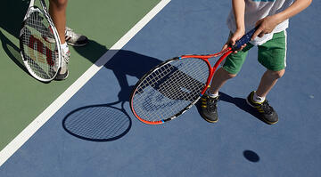 Young tennis player holding a racquet preparing to hit a tennis ball.