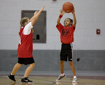 Two young kids playing a game of basketball.