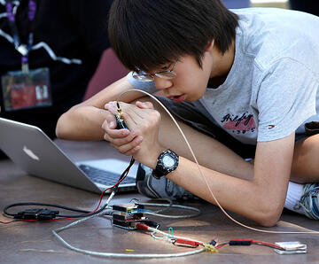 A student working intensely with his laptop computer.