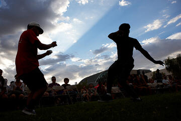 A silhouette of two young men during a cloudy afternoon.
