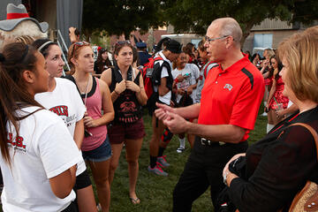 President Neal Smatresk talking to a group of young students.