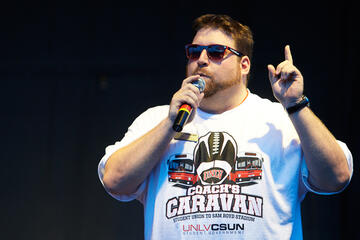 A young man speaking through a microphone.