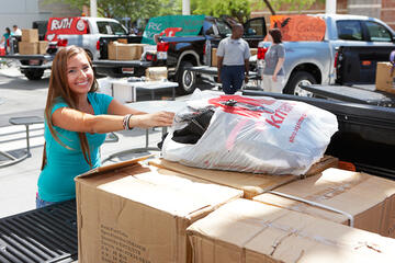 Student loading up a truck with donated items.
