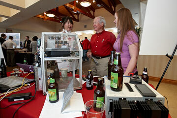 Automatic Bottle Capper: A team of engineering students, who also happen to be home brewing hobbyists, developed a small appliance for home brewers to cap their bottles as efficiently as manufacturers. The bottle capper applies the proper amount of force without shattering the glass. The device is also taps into social media by sending a Tweet each time a bottle is capped. Team members are Daniel Sigler, Amber Sypien, Zheng “Jinger” Zeng and Tony Filipiak . Pictured: Zeng and Sypien explain the project to s