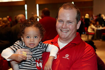 UNLV employee and child posing at holiday reception.