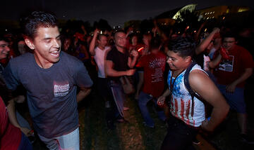 Night shot view of two students dancing at a UNLV campus gathering.