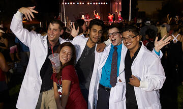 Group of students wearing lab coats and posing for the picture.