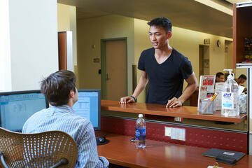 A student asking a library staff member for help.