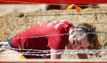 Isabel Guerra finds her way through the barbed wire of the Kiss of Mud 2.0 obstacle.