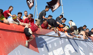 Team members help each other complete obstacles.