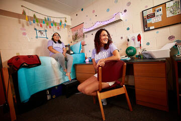Dakota Polk, left, and Ashley Hernandez are both junior transfers--Polk from Southern California now double majoring in theater and psychology, and pre-nursing student Hernandez from Brooklyn. Polk busted out old scrapbook paper to make the confetti wall, while the pair stayed up until 4 a.m. one night to get the decorations just so.