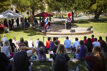 Students sitting outside during a daytime Presidential Debate event.
