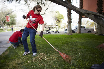 Erica Marti, coordinator for the EPSCoR Solar Energy, Water, Environment Nexus grant,&nbsp;rakes up near the Flora Dungan Humanities building. (Josh Hawkins/UNLV Creative Services)