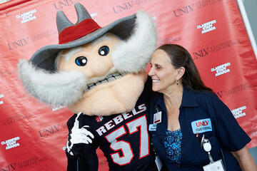 A Person taking a photo with the REB mascot 