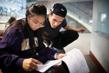 two students reviewing papers