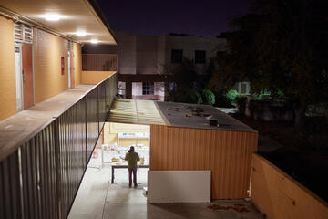 A professor works in the open doorway of a ceramics studio.