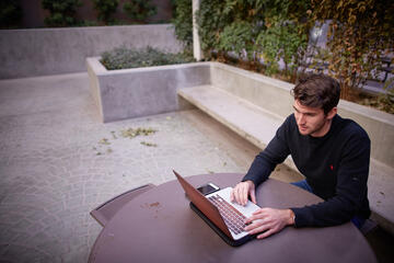 man studying at outside table