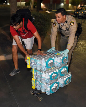 A student and police officer transport water.