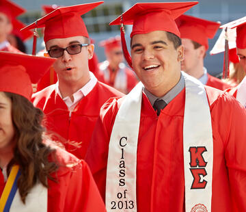 Smiling students waiting to be walked into Thomas & Mack Center for commencement.
