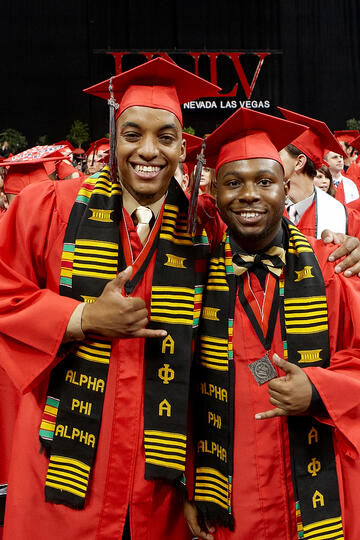 Two male students posing for camera during commencement.