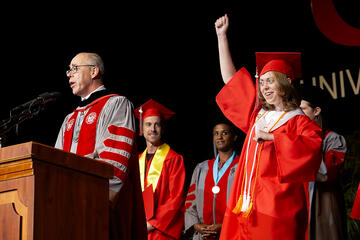 Student cheering during a commencement speech.