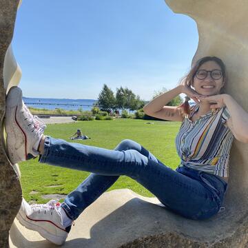 Ava poses on a molded concrete sculpture near a park