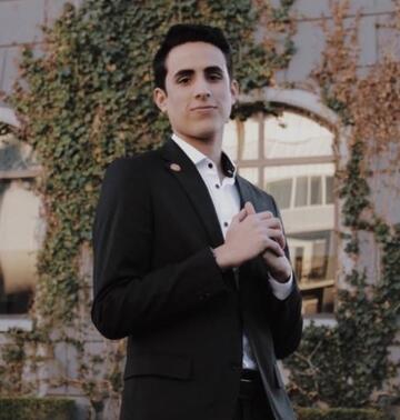 Abraham Lugo Bello wears a suit and poses for a photo