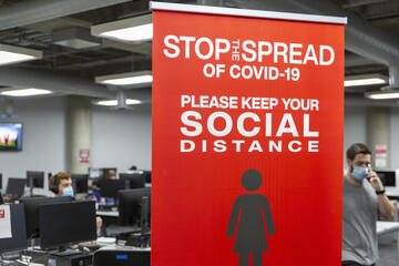 A red social distancing sign in computer lab on campus