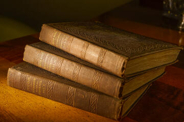 Three volumes stacked on their side comprise Charlotte Bronte's Jane Eyre.