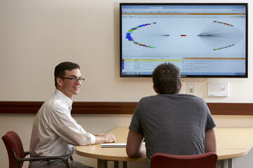 A student meeting with a library staff member in a conference room.