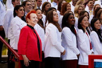 A group of students in white coats stand