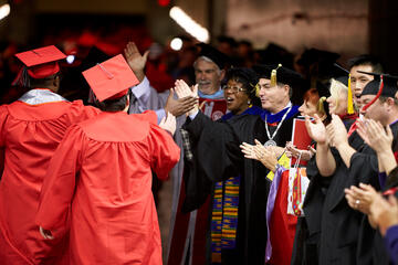 UNLV admistrators send the new graduates out into the world with high fives.