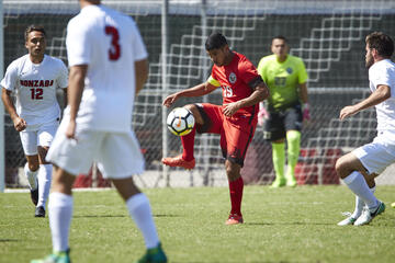 A soccer player dribbling the ball while avoiding the opponent