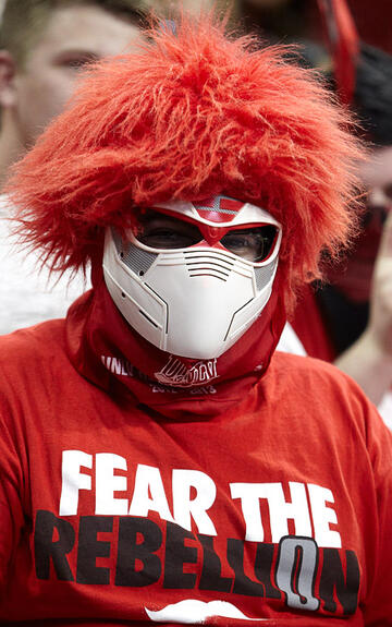 Student fan wearing a mask and wig to the UNLV athletic event.