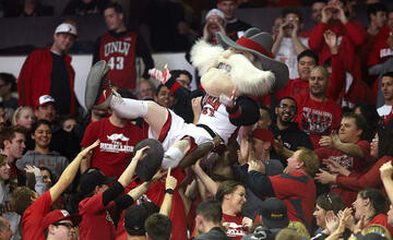 Hey Reb mascot being held up by crowd of students.