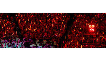 Students in the stands all hold red glow sticks during the pregame show.