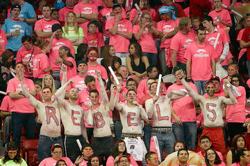 Group of students, shirtless, with letters painted on their chests spelling out rebels.