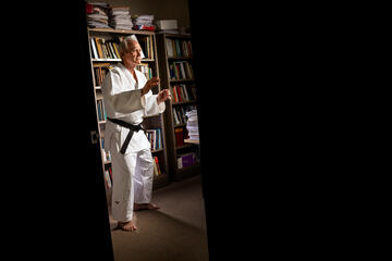 A judoka strikes a pose in front of some bookshelves