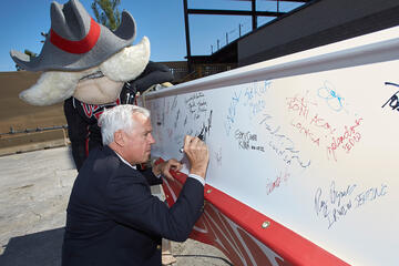 Dan Klaich, chancellor of the Nevada System of Higher Education, adds his name to the steel beam before it's moved into place. (R. Marsh Starks/UNLV Photo Services)