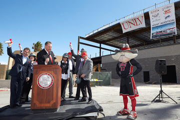 UNLV President Len Jessup, left, and other dignitaries blast air horns to signal a crane operator to begin lifting the final beam into place atop the Thomas & Mack Center west wing addition.&nbsp;(R. Marsh Starks/UNLV Photo Services)