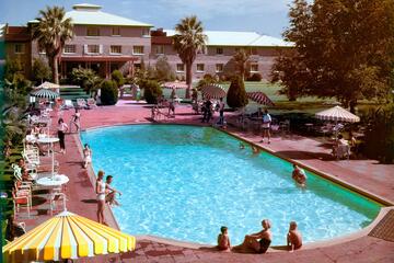 A shimmering blue pool surrounded by hotel guests
