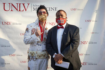An Elvis impersonator poses with UNLV President Keith E. Whitfield.