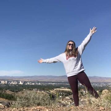 A student wearing a UNLV sweatshirt overlooks a city skyline (Elizabeth General)