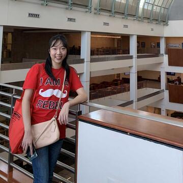 Student standing on the second level of the library (Kelly Chung)