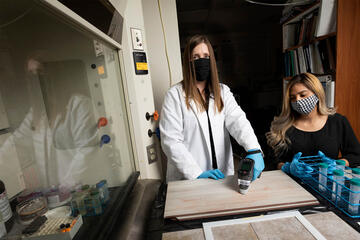 Two women examine tile