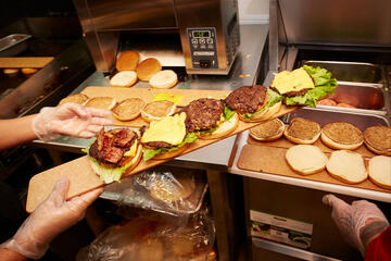 employee prepares burgers