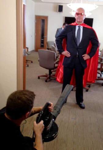 A leaf blower gives alumnus Chip Johnson's cape some movement.